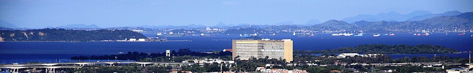 Cidade Universitária da Universidade Federal do Rio de Janeiro vista a partir da Igreja da Penha: ao centro, o Hospital Universitário Clementino Fraga Filho e, ao fundo, a Baía de Guanabara